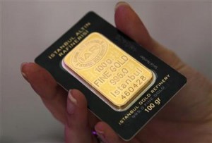 An employee holds a bar of 100 gram fine gold at a branch of Istanbul Gold Refinery in Istanbul