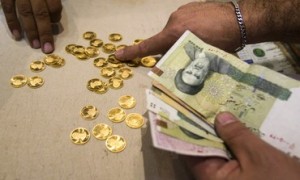 A customer buys Iranian gold coins at a currency exchange office in Tehran