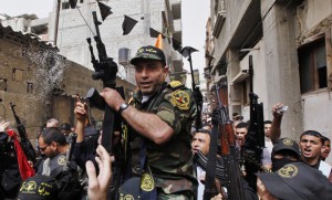 Freed Palestinian prisoner Baroud holds a gun as he carried on the shoulders of Islamic Jihad militants through crowds of people, as he arrives at his home in the northern Gaza Strip