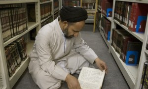 A cleric reads a book in the library of a religious research center associated with the seminary in Qom