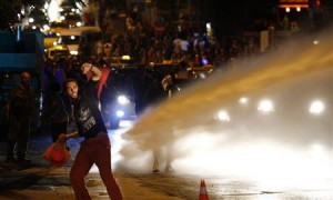 An anti-government protester throws stones as they clash with riot police in central Ankara