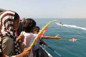 Iranian children throw flowers into the