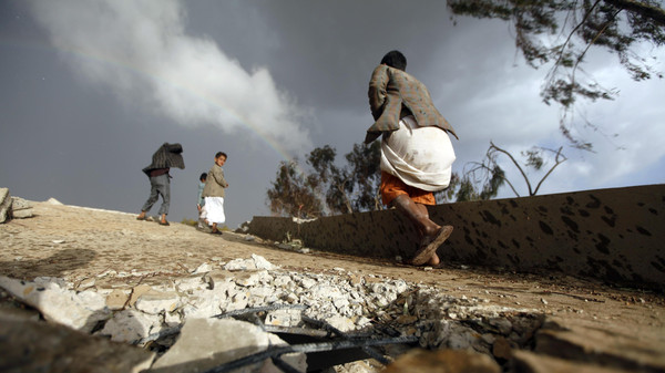 Boys walk on the ruins of their school which was bombed by Shi'ite militants of the Shi'ite al-Houthi group during recent conflicts against local tribes in the Hamdan area west of the Yemeni capital Sanaa