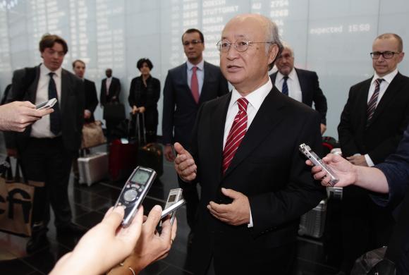 IAEA Director General Amano talks to the media as he arrives at Vienna's airport