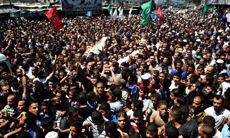 Crowds gather for the funeral of three senior Hamas commanders in Gaza.