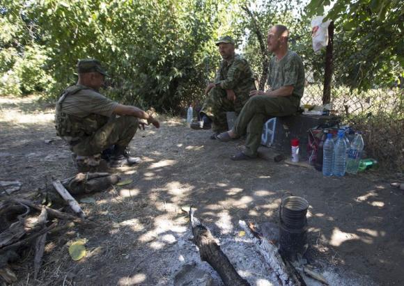 Armed pro-Russian separatists rest in the southern coastal town of Novoazovsk