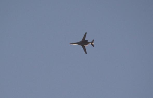 Jet from the U.S.-led coalition flies in the sky over the Syrian town of Kobani as seen from a hill in Tal-Hajeb village that overlooks Kobani
