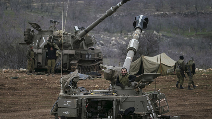 Israeli soldiers are seen next to mobile artillery units near the border with Syria in the Golan Heights
