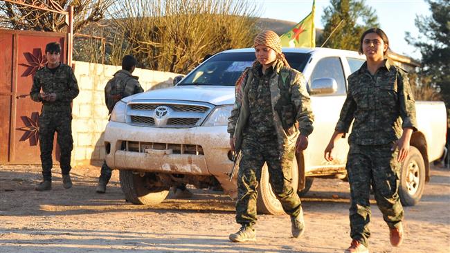 The fighters of Kurdish Peoples Protection Units (YPG) walk in Syrias northeastern town of Tel Hamis after retaking parts of the town following days of clashes with ISIL militants, February 26, 2015. ( AFP)