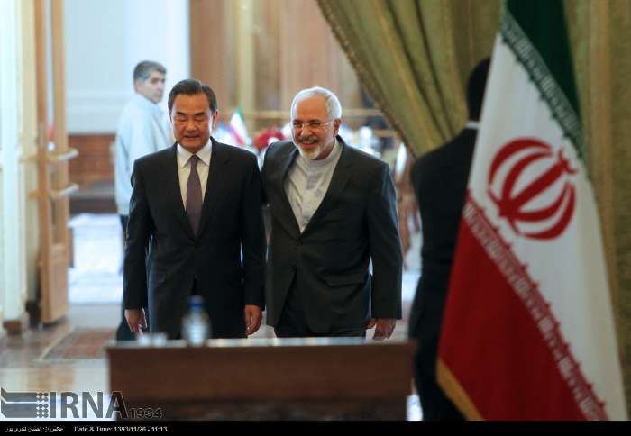 Chinese Foreign Minister Wang Yi, left, gestures during a joint press conference with his Iranian counterpart Mohammad Javad Zarif, in Tehran, Iran, Sunday, Feb. 15, 2015.