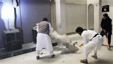 In this image made from video posted on a social media account affiliated with the Islamic State group on Thursday, Feb. 26, 2015, which has been verified and is consistent with other AP reporting, militants take sledgehammers to an ancient artifact in the Ninevah Museum in Mosul, Iraq. The extremist group has destroyed a number of shrines --including Muslim holy sites -- in order to eliminate what it views as heresy. The militants are also believed to have sold ancient artifacts on the black market in order to finance their bloody campaign across the region. (AP Photo via militant social media account)