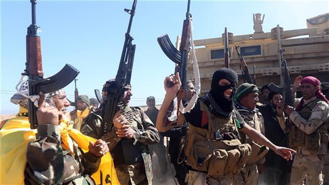 Iraqi volunteer fighters celebrate as they advance into Tikrit, 160 km north of Baghdad, during a military operation to regain the city from ISIL Takfiri militants, on March 11, 2015. (AFP photo)